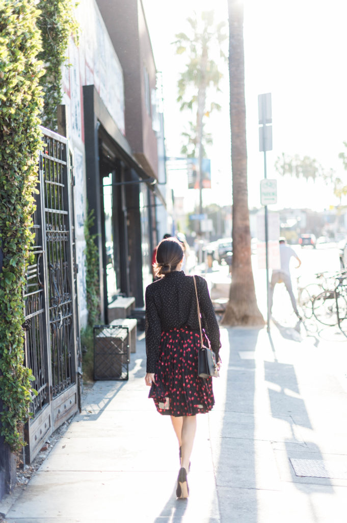 Lifestyle and corporate blogger Amanda Warsavsky wearing a J. Crew cherry skirt and a Banana Republic black bow blouse and Gucci bag