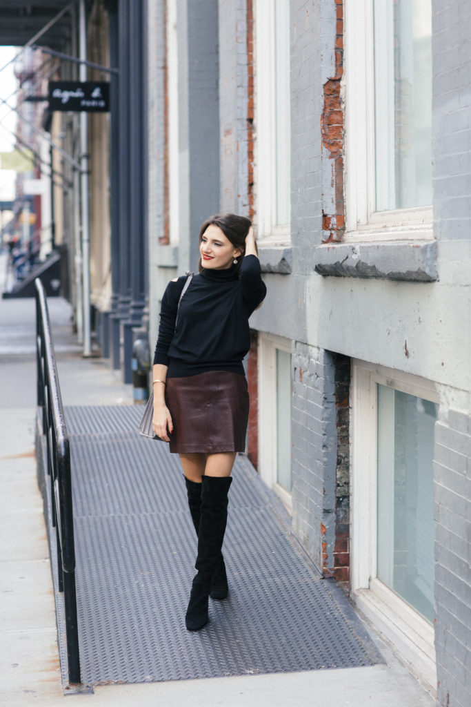 Lifestyle and Corporate blogger Amanda Warsavsky wearing a leather skirt, cold shoulder sweater, and over-the-knee boots