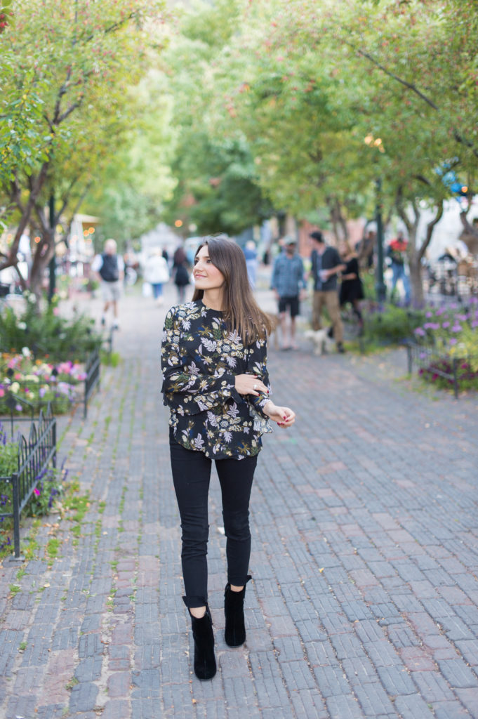 Lifestyle and corporate bogger Amanda Warsavsky wearing black Frame jeans, an A.L.C. ruffle top, and black velvet boots
