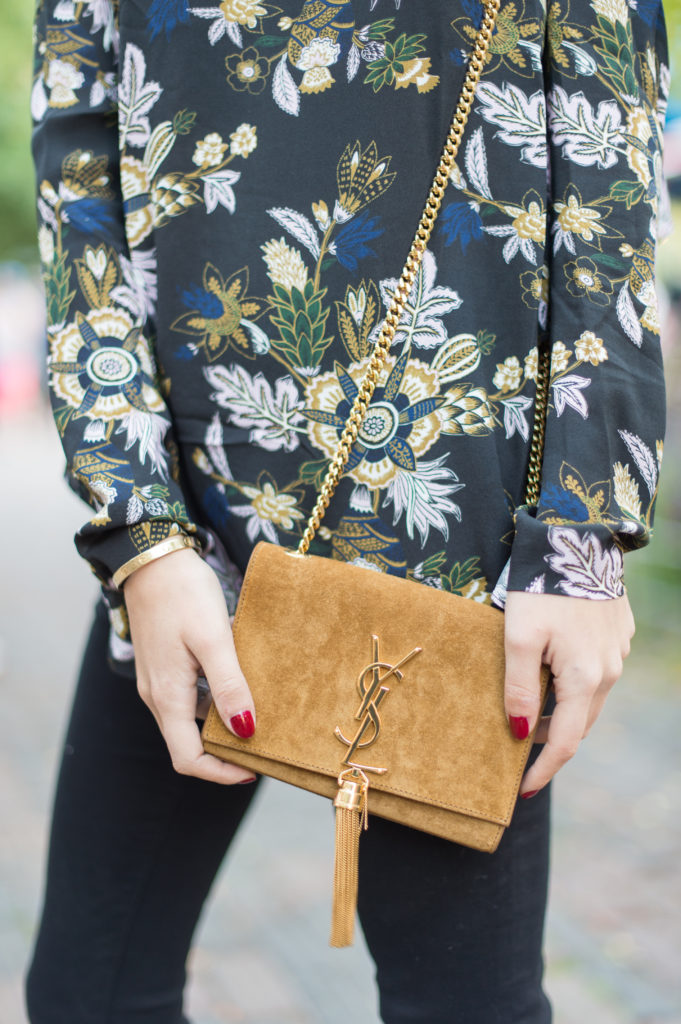 Lifestyle and corporate bogger Amanda Warsavsky wearing black Frame jeans, an A.L.C. ruffle top and Saint Laurent bag