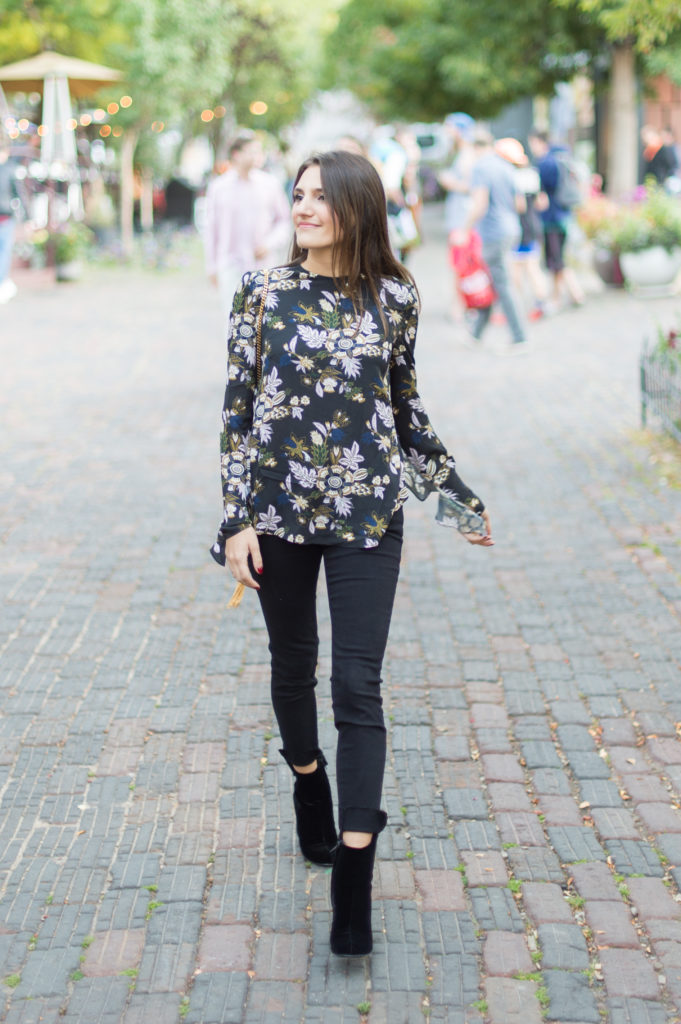 Lifestyle and corporate bogger Amanda Warsavsky wearing black Frame jeans, an A.L.C. ruffle top, and black velvet boots