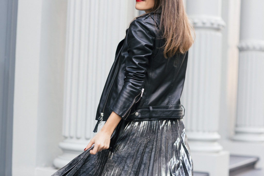 Lifestyle and corporate fashion blogger Amanda Warsavsky wearing a silver pleated skirt and black leather jacket for holiday inspiration
