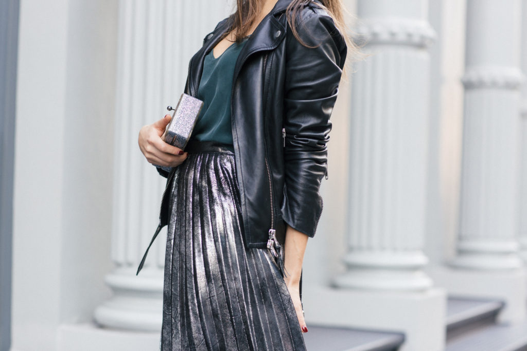 Lifestyle and corporate fashion blogger Amanda Warsavsky wearing a silver pleated skirt and black leather jacket for holiday inspiration