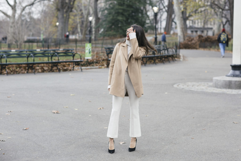Corporate blogger That Pencil Skirt wearing winter white theory pants, a white turtleneck and a tan open cashmere coat