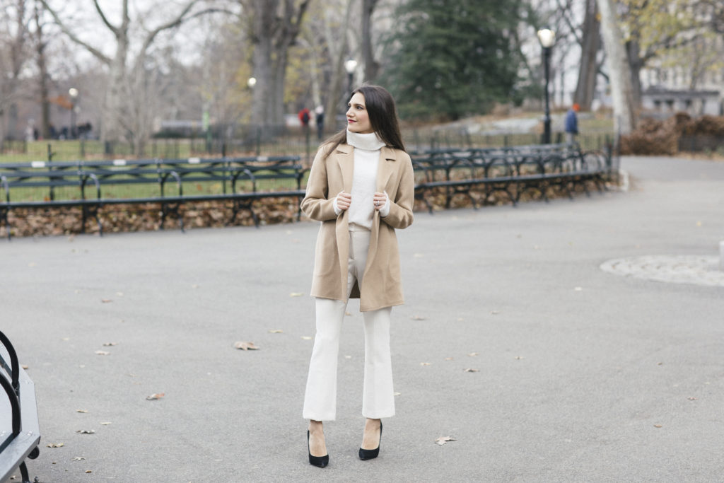 Corporate blogger That Pencil Skirt wearing winter white theory pants, a white turtleneck and a tan open cashmere coat