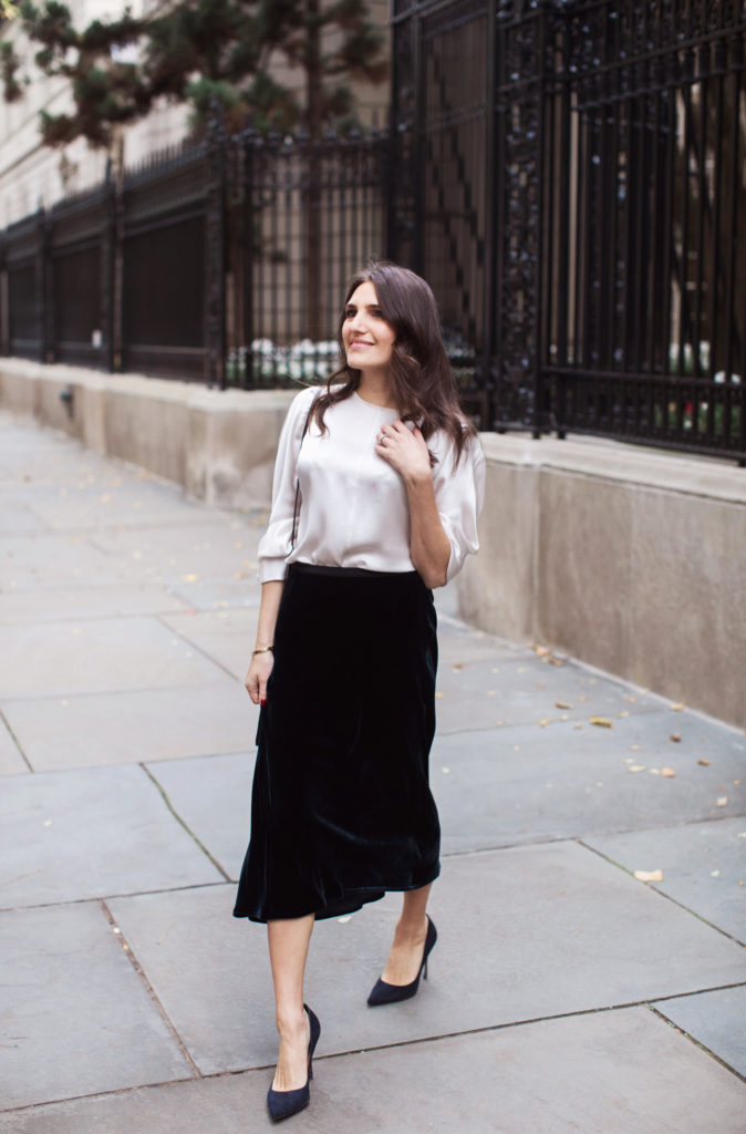 That Pencil Skirt, a lifestyle and workwear blogger wearing a Vince Velvet midi skirt with a Vince silk silver blouse and navy suede pumps