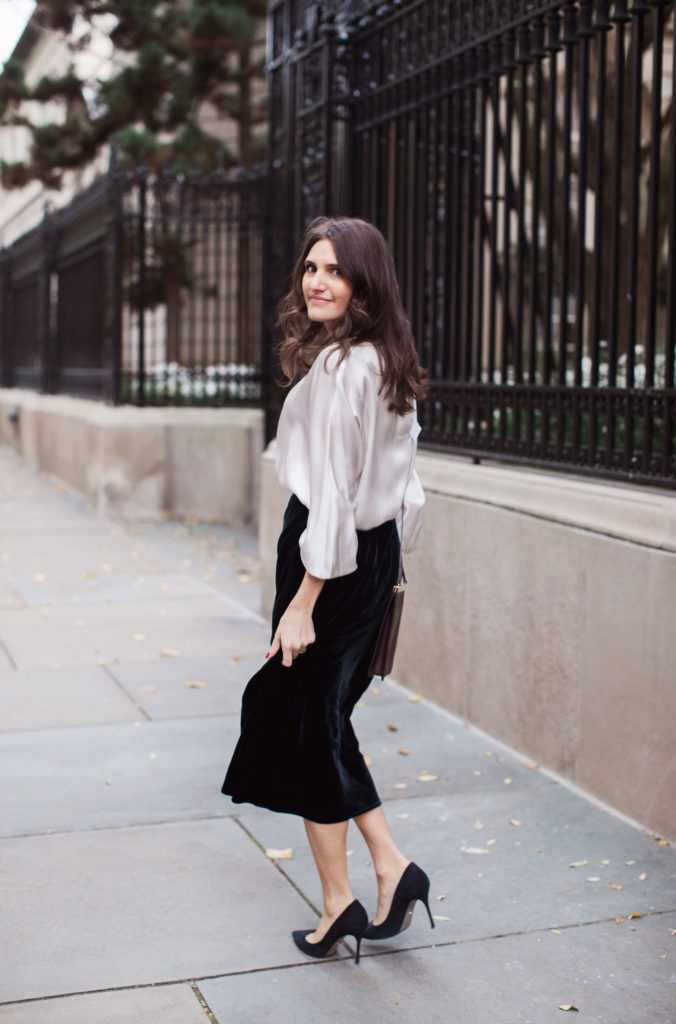 That Pencil Skirt, a lifestyle and workwear blogger wearing a Vince Velvet midi skirt with a Vince silk silver blouse and navy suede pumps