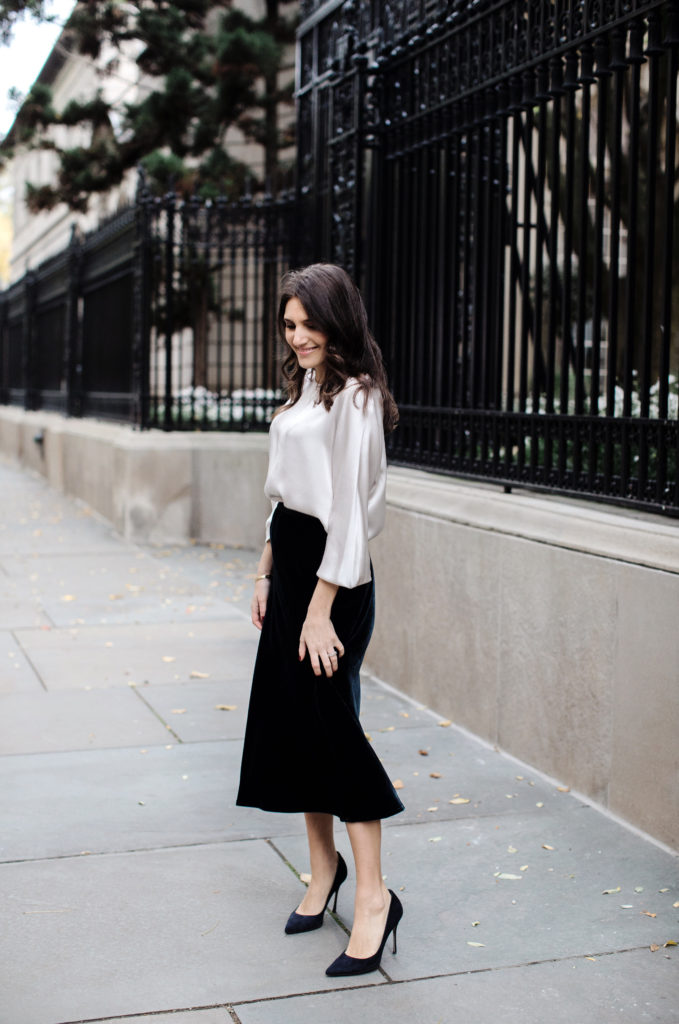 That Pencil Skirt, a lifestyle and workwear blogger wearing a Vince Velvet midi skirt with a Vince silk silver blouse and navy suede pumps