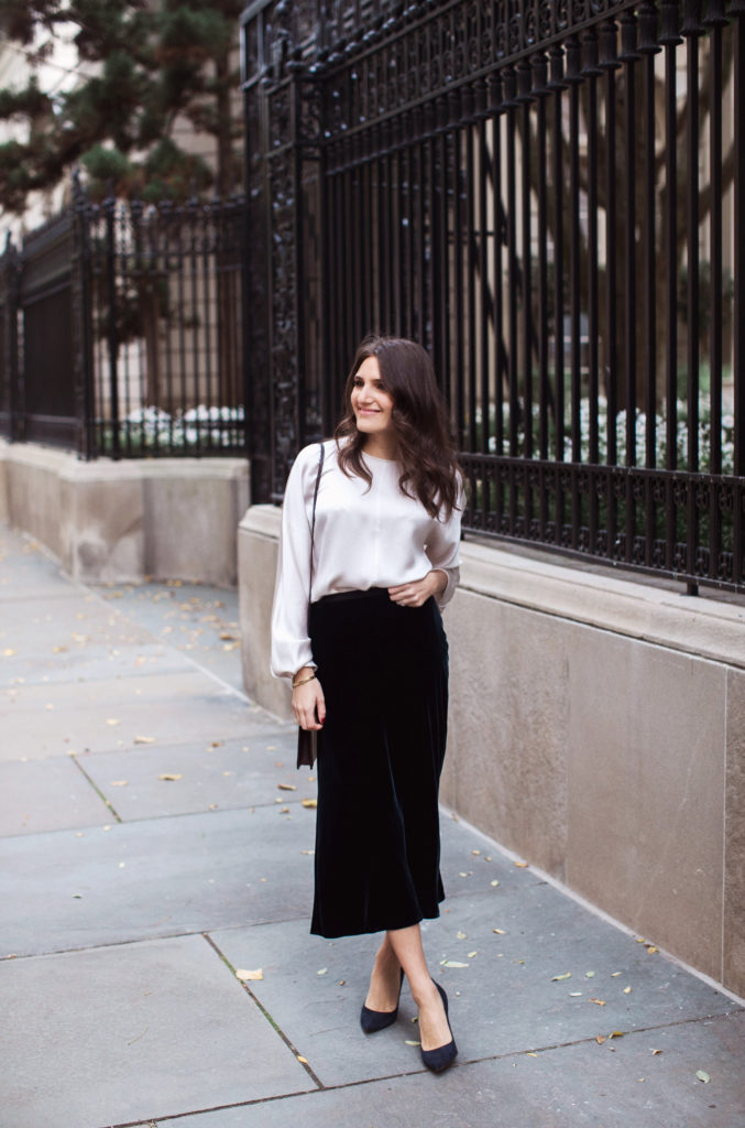 That Pencil Skirt, a lifestyle and workwear blogger wearing a Vince Velvet midi skirt with a Vince silk silver blouse and navy suede pumps