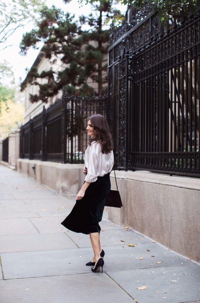 That Pencil Skirt, a lifestyle and workwear blogger wearing a Vince Velvet midi skirt with a Vince silk silver blouse and navy suede pumps