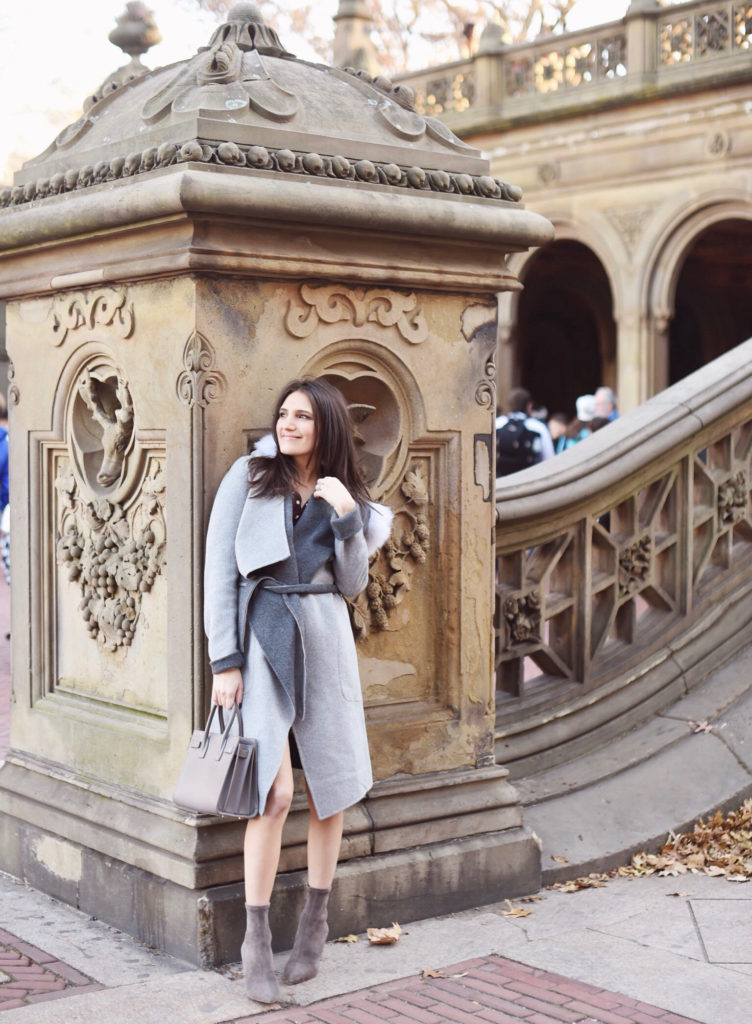 That Pencil Skirt, a lifestyle and work wear blogger, wearing a Soia and Kyo gray wrap coat with a fur hood, and Jimmy Choo gray sock ankle boots