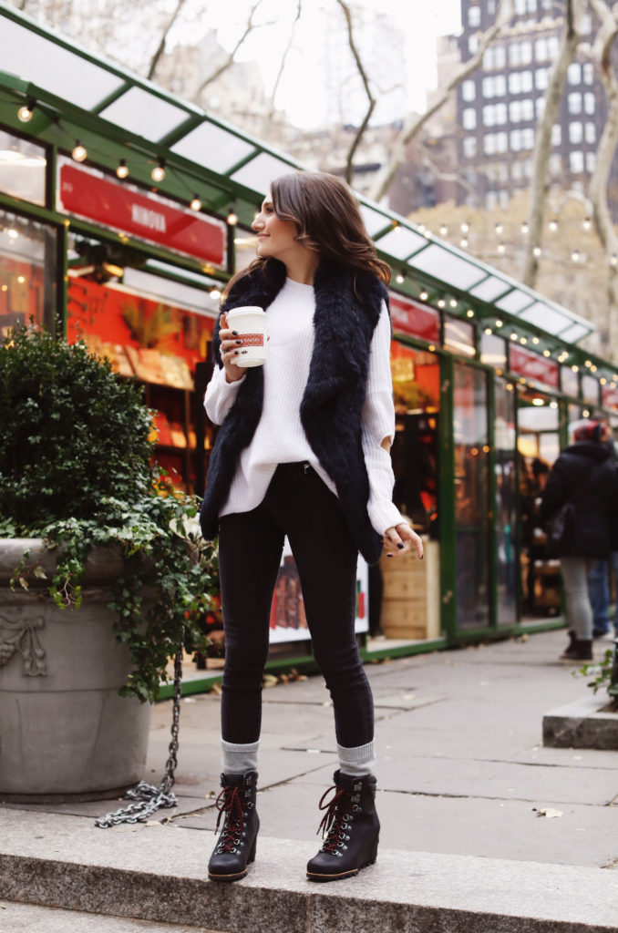 Lifeistyle blogger That Pencil Skirt wearing Sorel boots, cashmere socks. a black fur vest and an Aqua sweater all bought at Bloomingdales