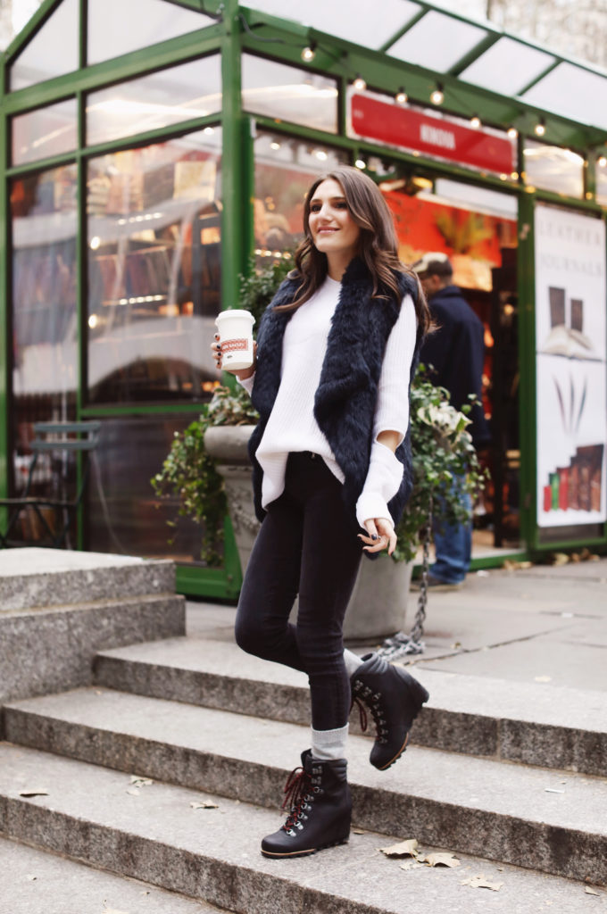 Lifeistyle blogger That Pencil Skirt wearing Sorel boots, cashmere socks. a black fur vest and an Aqua sweater all bought at Bloomingdales