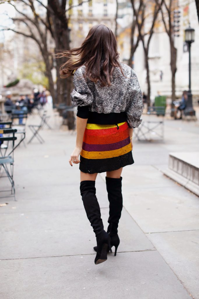 That Pencil Skirt, a fashion blogger, wearing an Alice and Olivia striped sequin color mini dress, with a Philip Lim silver embroidered bomber jacket and over the knee black suede boots