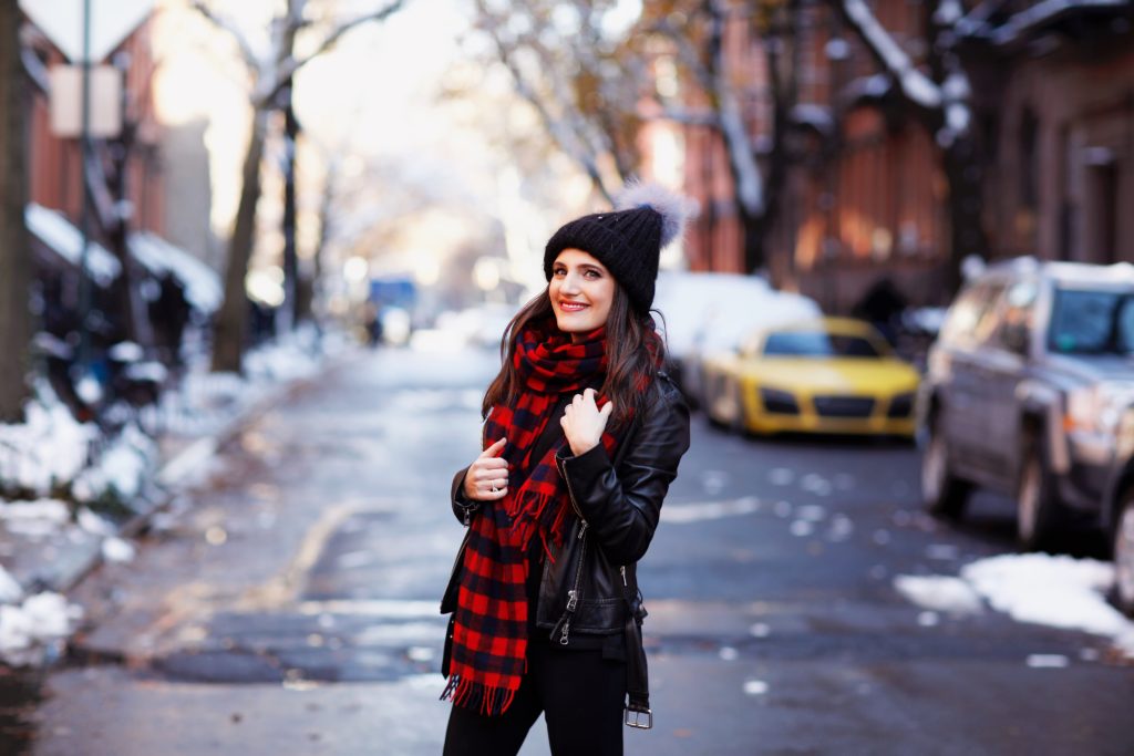 That Pencil Skirt, a lifestyle blogger, wearing Ann Taylor maternity friendly leggins with a front slit, a red and blue check scarf and a pom pom hat